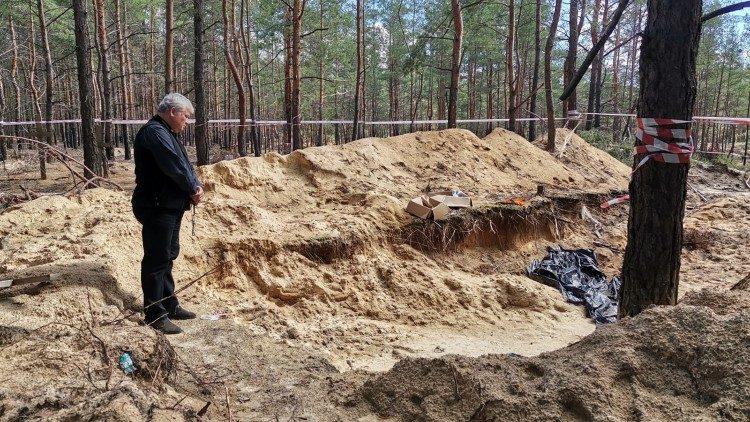 ĐHY Krajewski cầu nguyện trước các ngôi mộ tập thể ở Ucraina