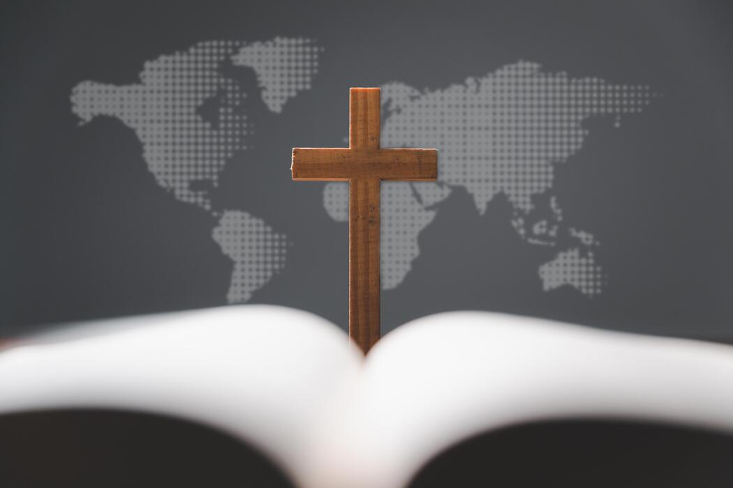 crosswithopenholybibleontablewithworldmapblurbackgroundmissionevangelismandgospelonworldcopyspacefortextchristianbackgroundforgreatcommissionorearthdayconceptphoto